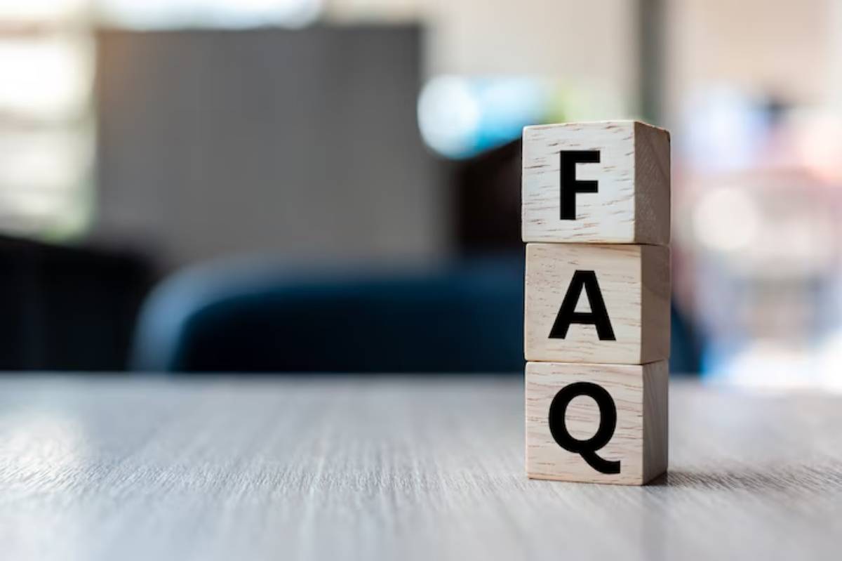 A stack of wooden blocks spelling FAQ on a desk, symbolizing frequently asked questions in a bright, modern setting.